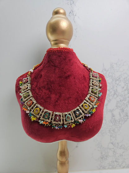 Decorative red velvet collar with colorful gemstones on a mannequin head against a light background