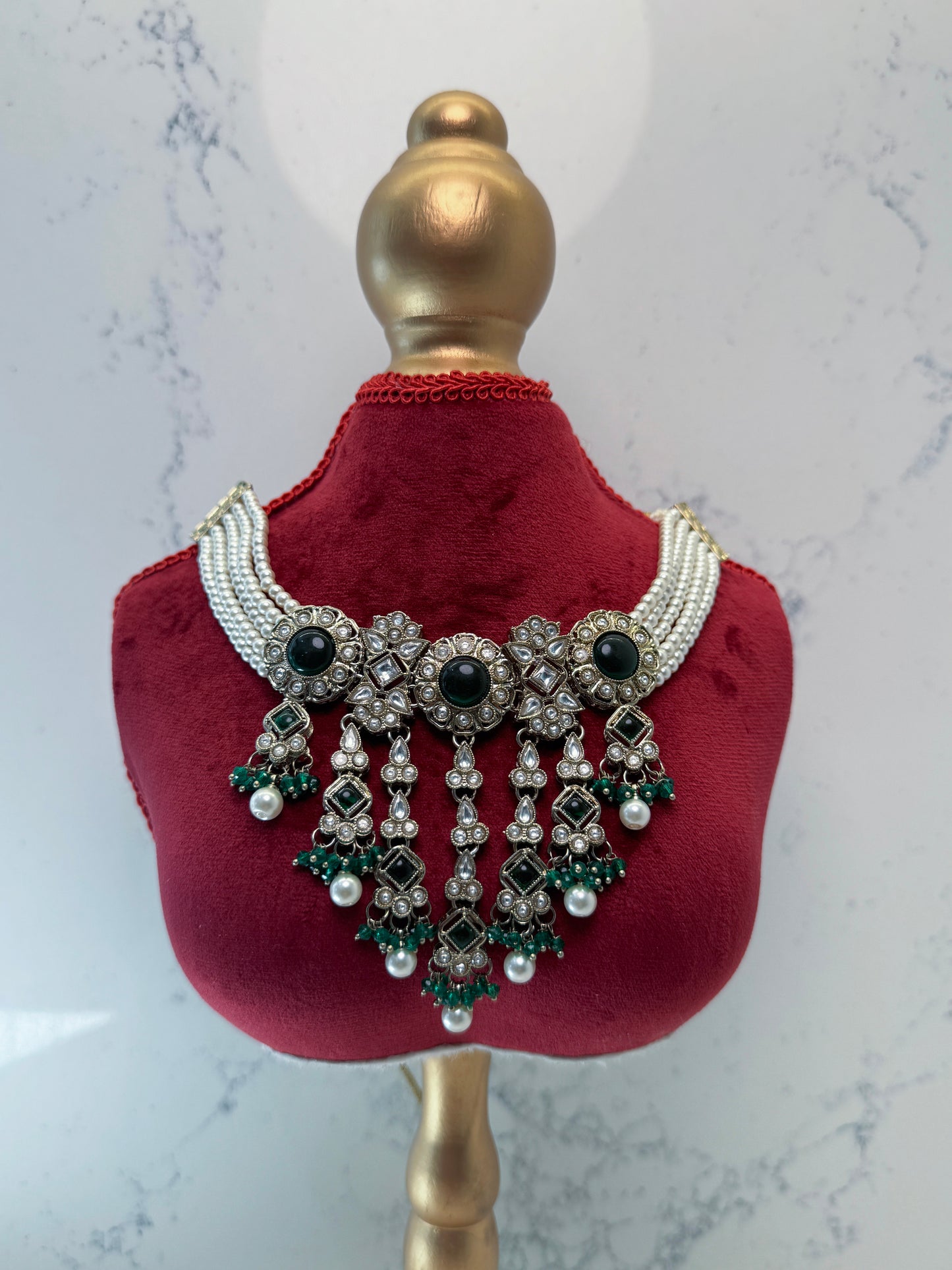 Decorative necklace on a mannequin bust with a marble background